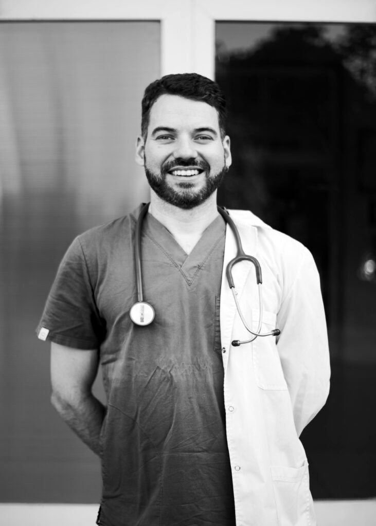 Black and white portrait of a smiling doctor in Buenos Aires, showcasing medical professionalism.
